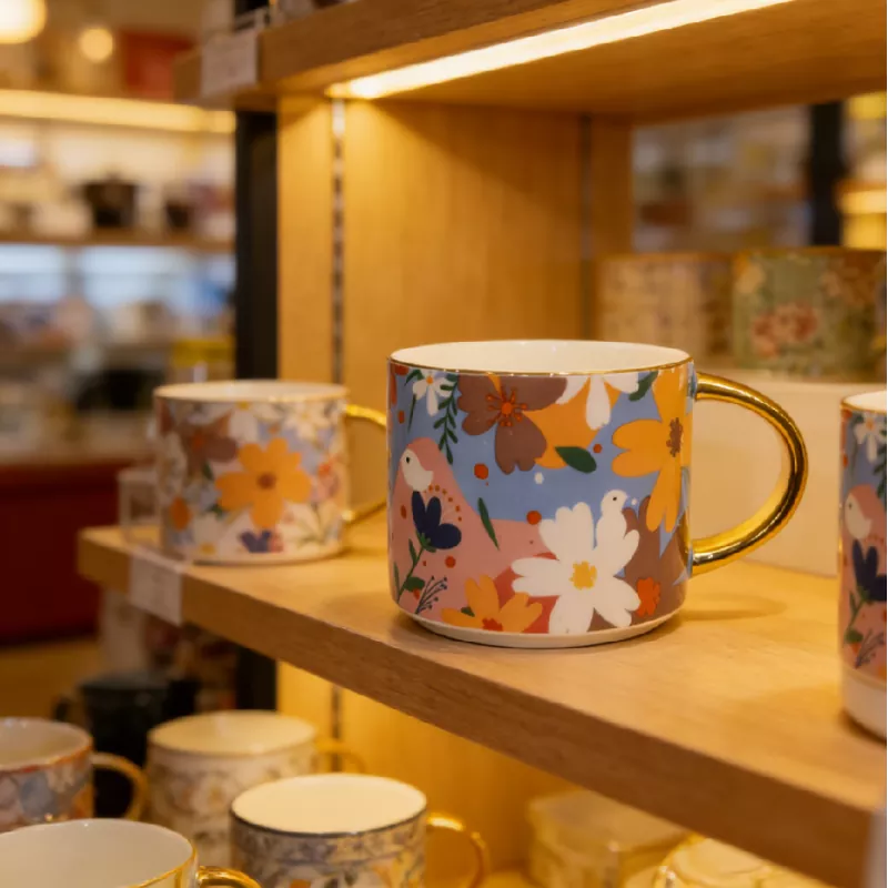 Levendige bloemenkeramische mok met gouden rand Levendige bloemenkeramische mok met gouden rand